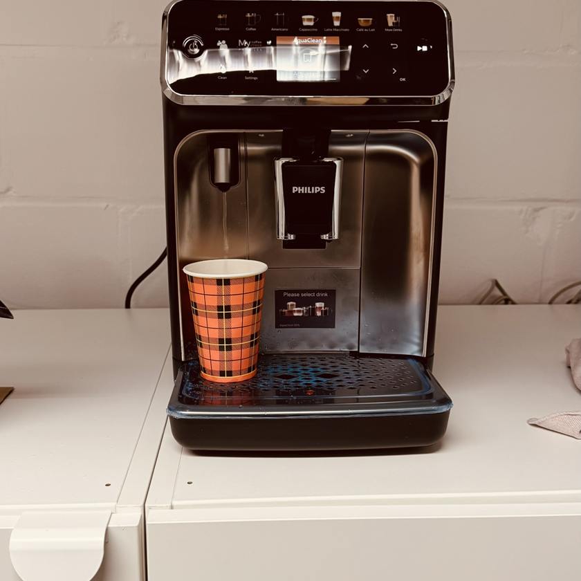 De koffiemachine van LUX 2.0 met een beker koffie om mee te nemen