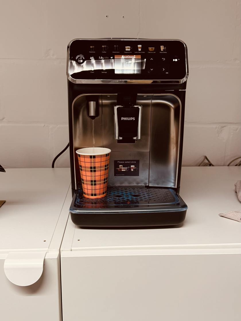 De koffiemachine van LUX 2.0 met een beker koffie om mee te nemen